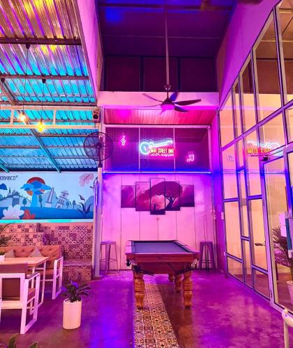 a ping pong table in a room with purple lights at BaobaBed Lodge, Yangon in Yangon