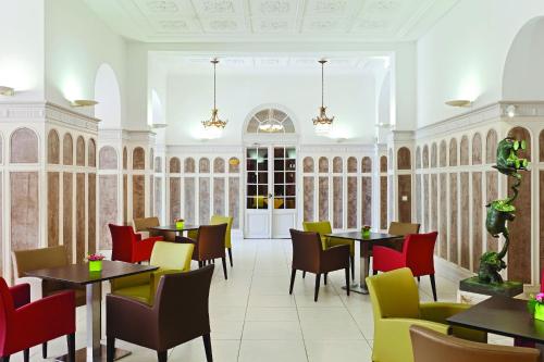 a restaurant with tables and chairs in a room at Hôtel Vacances Bleues Royal Westminster in Menton