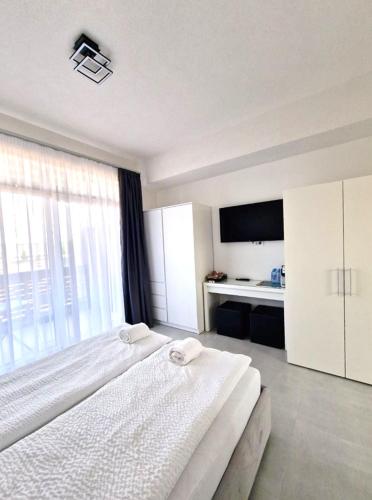 a bedroom with two beds and a large window at BB Residence in Arad