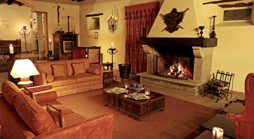 a living room with a couch and a fireplace at Hotel Real d Obidos in Óbidos