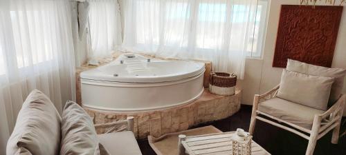 a bath tub in a room with a chair and a chair at Villa Las Estrellas Tulum - located at the party zone in Tulum