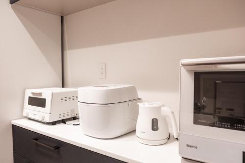 a kitchen counter with a microwave and appliances on it at Mova Villa Haramizu in Kikuchi
