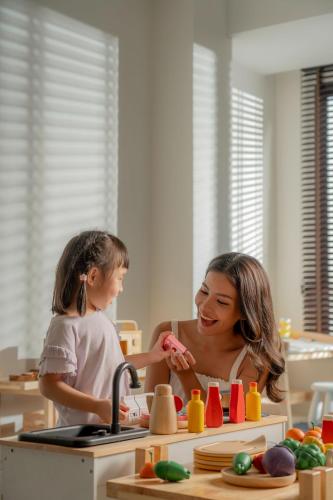a woman standing next to a child in a kitchen at Pranakorn Heritage Hotel in Bangkok