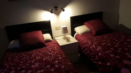 a bedroom with two beds and a lamp on a night stand at Hostal Fornet Altea in Altea