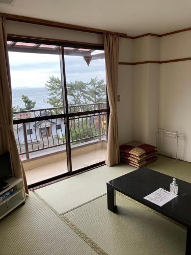 a living room with a large window with a view at WASUKIBASEびわ湖GuestHouse in Kaizu