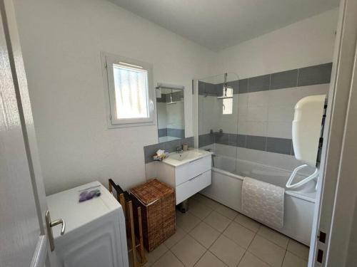 La salle de bains blanche est pourvue d'un lavabo et d'une baignoire. dans l'établissement Costa Verde - Appart 6 places avec piscine en bord mer, à Poggio-Mezzana