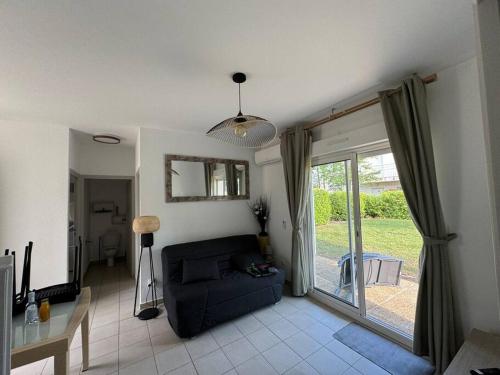 un salon avec un canapé et une porte coulissante en verre dans l'établissement Costa Verde - Appart 6 places avec piscine en bord mer, à Poggio-Mezzana