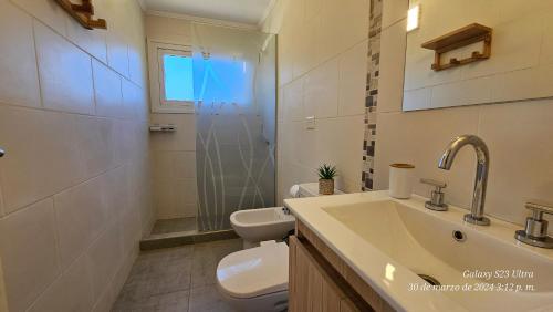 Un baño con lavabo, inodoro y ducha. en Camino al Rio, en Dina Huapi