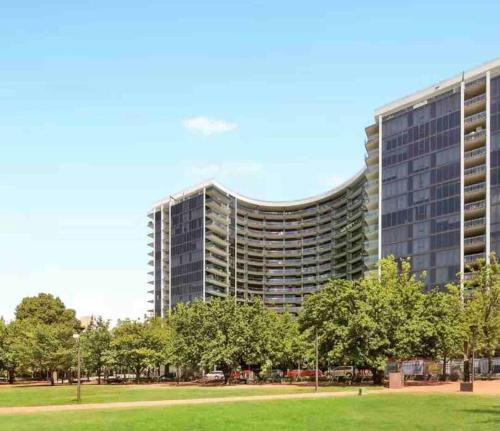 a large building with a park in front of it at City Comfy Apartment in Canberra