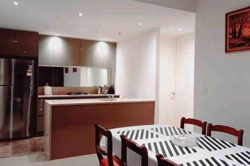 a kitchen with a table and chairs and a kitchen with a refrigerator at City Comfy Apartment in Canberra
