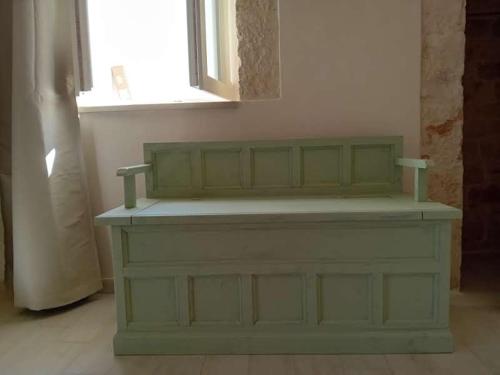 a green bench in a room with a window at Pietra Di Puglia in Monopoli