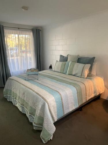 a bedroom with a large bed with a window at Bungalow Motel Gilgandra in Gilgandra