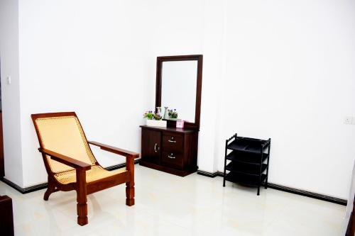 a room with a chair and a dresser and a mirror at Sasanda Villa and Yala Safari Place in Tissamaharama