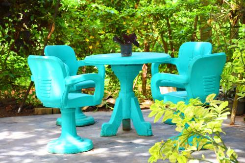 four blue chairs around a table with a vase on it at Sasanda Villa and Yala Safari Place in Tissamaharama