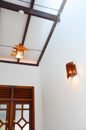 two lights on a ceiling next to a door at Sasanda Villa and Yala Safari Place in Tissamaharama