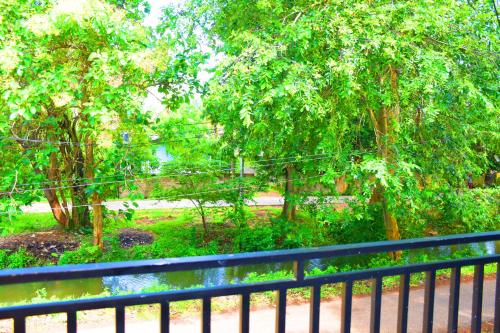 a black fence next to a park with trees at Sasanda Villa and Yala Safari Place in Tissamaharama