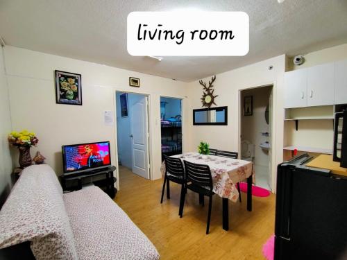 a living room with a table and a dining room at Two-Bedroom at San Remo Oasis in Cebu City