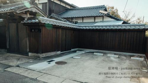 a building with a gate and a concrete patio at 古民家1棟貸し 今魚店の家 in Hagi