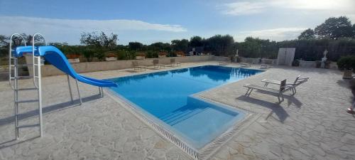 a swimming pool with a blue slide and a playground at Villa Clara in Alberobello