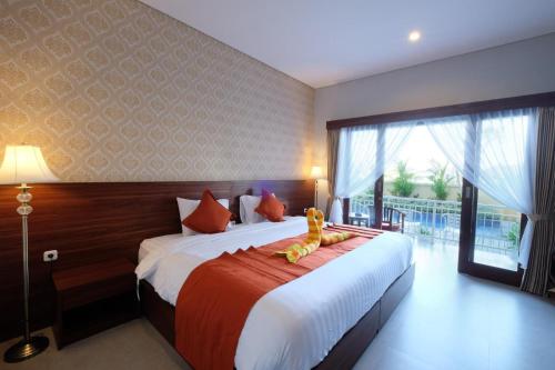 a bedroom with a large bed with a stuffed animal on it at Puspa Canggu in Canggu
