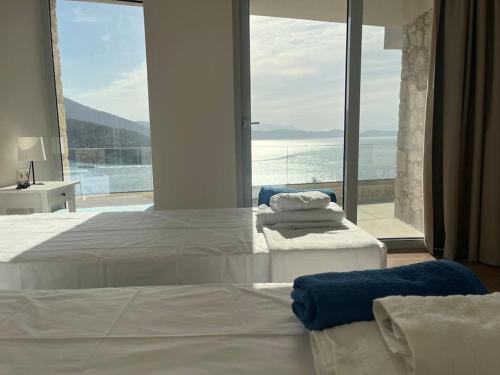 a bedroom with a bed with a view of the ocean at Villa Infinia, Lefkada in Sivota
