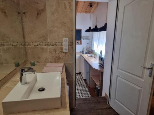 La salle de bains est pourvue d'un lavabo blanc et d'une cuisine. dans l'établissement Maisonnette et jardin à 5mn de la plage La Ciotat, à Ceyreste