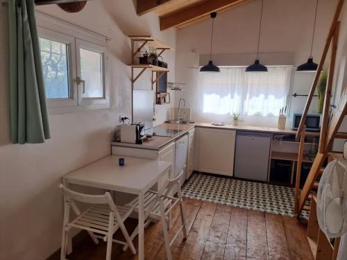 une cuisine avec une table et des chaises dans une pièce dans l'établissement Maisonnette et jardin à 5mn de la plage La Ciotat, à Ceyreste