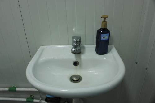 a bathroom sink with a bottle of soap on it at Mahane in Tirana