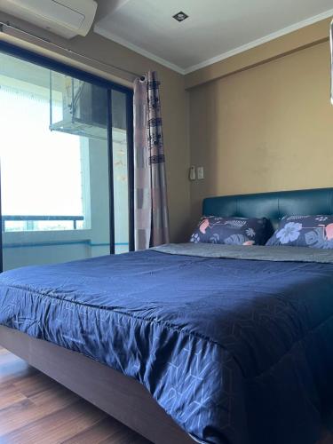 a blue bed in a bedroom with a window at Regent Srinakarin18 in Amphoe Phra Khanong