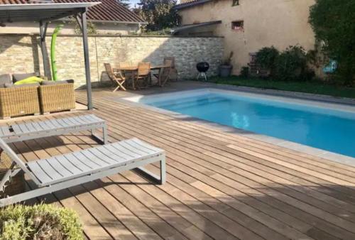 une terrasse en bois à côté d'une piscine avec un banc dans l'établissement La parenthèse, à Charnay-lès-Mâcon