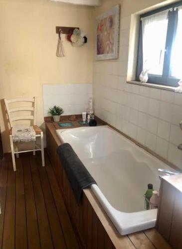 une baignoire dans une salle de bain avec une fenêtre dans l'établissement La parenthèse, à Charnay-lès-Mâcon