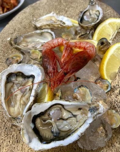 a plate of oysters with shrimp and lemon slices at Casa Gioconda Bed & Breakfast in Nuxis