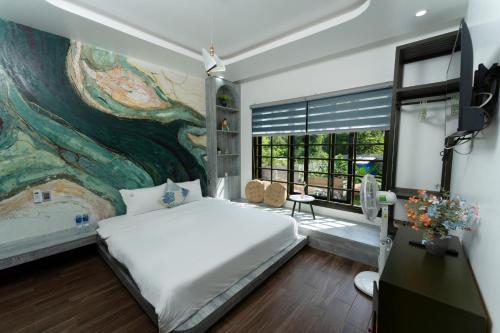 a bedroom with a large painting on the wall at Win Hotel in Thôn Dương Xuân Hạ