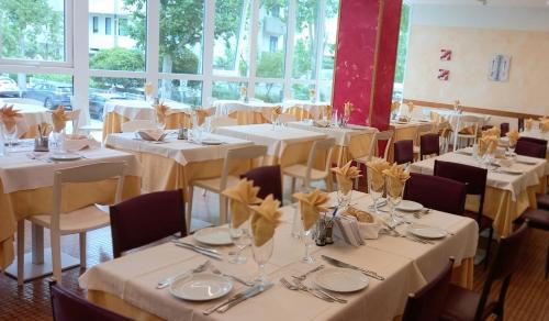 a dining room with white tables and chairs at Hotel Bologna in Misano Adriatico