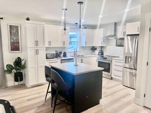 a kitchen with white cabinets and a blue island in it at Platinum Homes Moncton, Dieppe in Dieppe