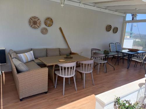 a living room with a couch and a table and chairs at Elia Studios in Palekastron
