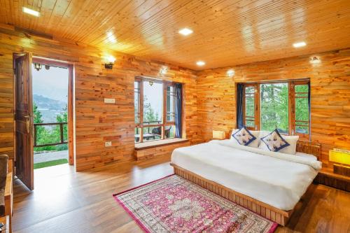 a bedroom with a large bed in a wooden room at WoodVista Cottages By Jomotel in Shimla