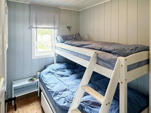 ein Schlafzimmer mit zwei Etagenbetten und einem Fenster in der Unterkunft 9 person holiday home in Korshamn-By Traum in Korshamn