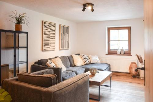 a living room with a couch and a table at Stanzls - Lodge am Lech in Weissenbach am Lech