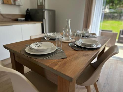 a wooden table with plates and wine glasses on it at Al País Del Mesturet in Graulhet