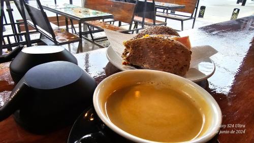 a table with a cup of coffee and a piece of bread at Ocho Cabañas in San Carlos de Bariloche
