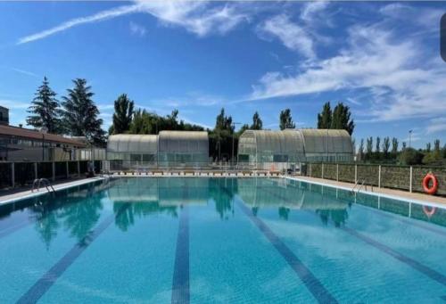 a large swimming pool with blue water at Alojamiento Museo Carmelitano Alba de Tormes in Alba de Tormes
