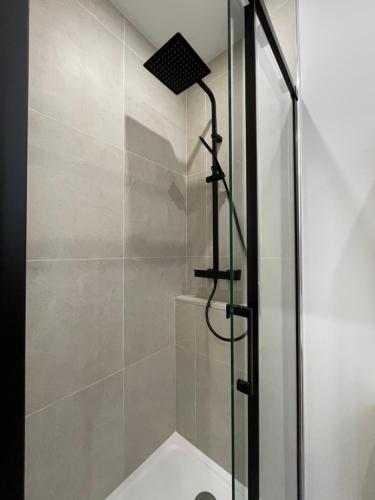 une salle de bain avec une douche avec une porte vitrée dans l'établissement Appart 2 pièces rénové, centre-ville, au Havre