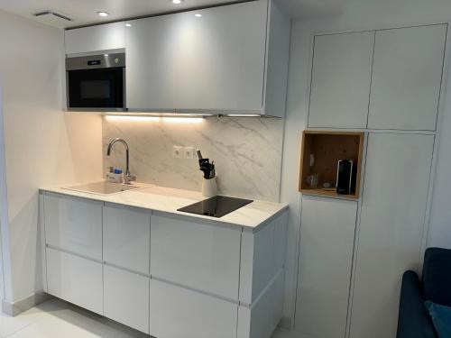 Una cocina con gabinetes blancos y un fregadero. en Almar Studio - Albufeira - Praia dos pescadores, en Albufeira