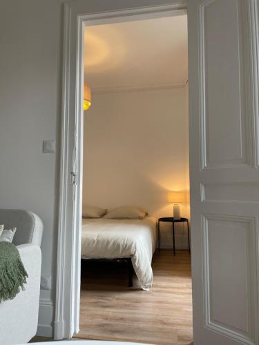 - une chambre avec un lit et une porte menant à une pièce dans l'établissement Appart 2 pièces rénové, centre-ville, au Havre