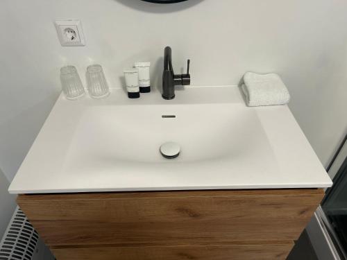 a bathroom counter with a white sink with cosmetics on it at B&B Noordoostpolder in Emmeloord
