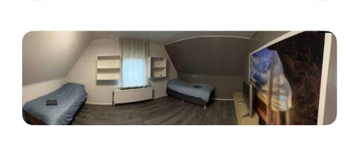 a small room with two beds and a tv at Zimmer 5 in Bullendorf