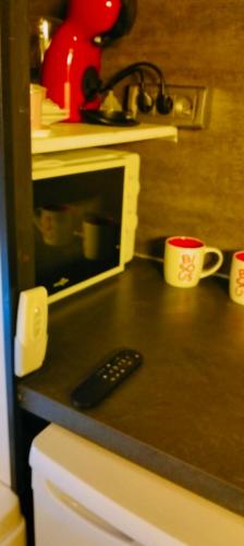 un comptoir de cuisine avec un micro-ondes et une télécommande dans l'établissement la love interdite chez love room Toulon, à Toulon