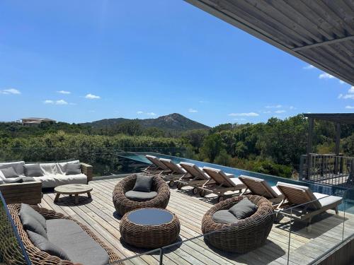 un ponte con sedie e mobili in vimini su una casa di Villa de luxe surplombant la mer, piscine suspendue a Pianottoli-Caldarello