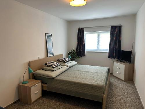 a small bedroom with a bed and a window at Vila u potoka in Jindrichuv Hradec